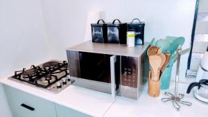 a microwave sitting on a counter next to a stove at Bethel apartments ug in Kampala +31 photos