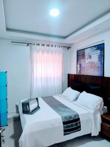 a bedroom with a large white bed with a large window at Bethel apartments ug in Kampala