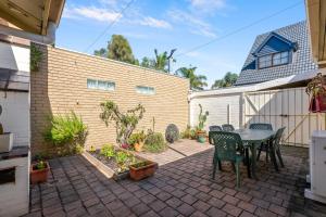 a patio with a table and chairs and plants at Spacious, Light filled, One Bedroom House by the Beach in Beaumaris +3 photos