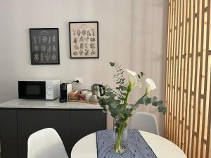 a kitchen with a table with a vase of flowers at TEODORA SUITE blue in Ravenna
