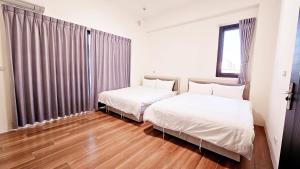 吉安郷にある65町遊趣の木製の床の部屋にベッドが2つあります