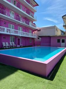a swimming pool in front of a pink building at Casa Barbie Costinesti in Costinesti