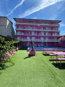 a pink building with picnic tables in front of it at Casa Barbie Costinesti in Costinesti