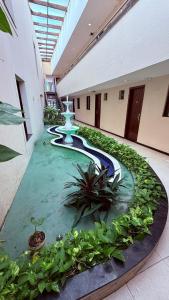 a room with a pool of water in a building with plants at Hotel Italia Beach - Na Beira Mar Natal RN in Natal