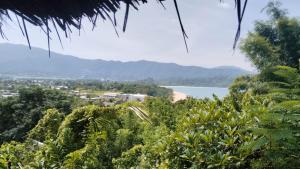 a view of a beach with mountains in the background at Bamboo Hut Alpha Hotel in Maluk +7 photos