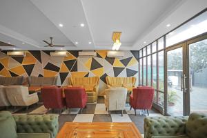 a lobby with chairs and tables and a wall of windows at Hotel O Heart Beat Hotel in Noida +21 photos
