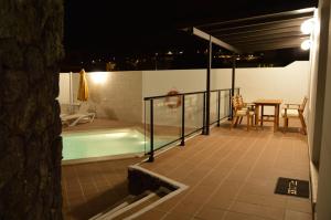 a balcony with a swimming pool and a table and a table at Casa Alba in Nazaret