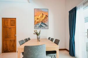 ein Esszimmer mit einem Holztisch und Stühlen in der Unterkunft 906 Bangkok City Center Single Pool Villa BTS Asok 5 Bedrooms 6 Bathrooms in Bangkok