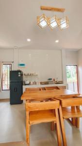 a kitchen with a wooden table and a refrigerator at 2-Bedroom Maduea Wan House in Ko Phangan