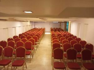 an empty hall with red chairs in a room at Silver Sands Hideaway Resort, Candolim in Candolim