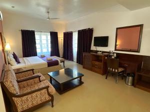 a hotel room with a bed and a desk at Silver Sands Hideaway Resort, Candolim in Candolim