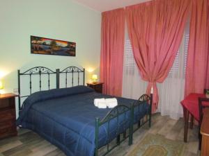 a bedroom with a blue bed and pink curtains at B&B Eco Dal Mare in Gallipoli