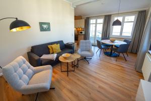 ein Wohnzimmer mit einer Couch und Stühlen und einem Tisch in der Unterkunft Villa Seerose - Appartement 11 in Ostseebad Sellin