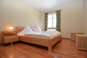 ein Schlafzimmer mit einem Bett mit weißen Laken und einem Fenster in der Unterkunft Villa Seerose - Appartement 11 in Ostseebad Sellin