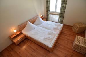 ein kleines Schlafzimmer mit einem Bett mit weißer Bettwäsche und Kissen in der Unterkunft Villa Seerose - Appartement 11 in Ostseebad Sellin