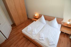 ein Schlafzimmer mit einem Bett mit weißen Laken und Kissen in der Unterkunft Villa Seerose - Appartement 11 in Ostseebad Sellin + 18 Fotos