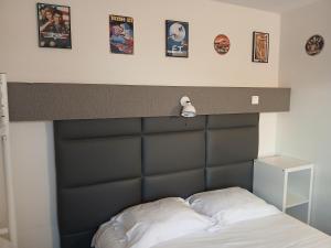 a bed with a black headboard with pictures above it at hôtel QUICK Palace Tours Nord in Tours