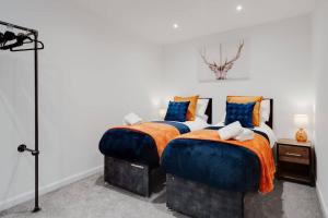 a bedroom with two beds with blue and orange sheets at Brighton Apt - 2 Bedroom Free Wi-Fi & Parking in Wallasey