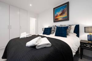 a bedroom with a bed with towels on it at Brighton Apt - 2 Bedroom Free Wi-Fi & Parking in Wallasey