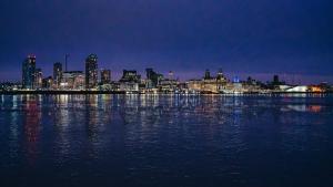 a view of a city from the water at night at Brighton Apt - 2 Bedroom Free Wi-Fi & Parking in Wallasey +51 photos