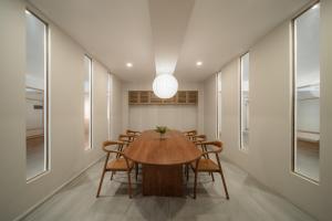a dining room with a wooden table and chairs at Mintara Hotel - โรงแรมมินธารา มีนบุรี in Min Buri