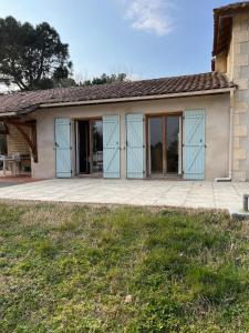 a house with glass doors on a patio at Maison de charme - piscine - coeur du Périgord ! in Saint-Georges-de-Blancaneix