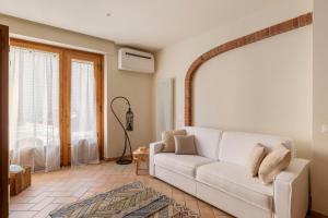 a living room with a white couch and a window at Casa Paolina in Viareggio