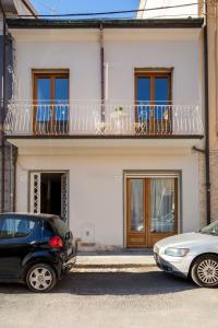 two cars parked in front of a house with a balcony at Casa Paolina in Viareggio