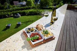 een dienblad met eten op een tafel met glazen wijn bij Pension Ježník in Krnov