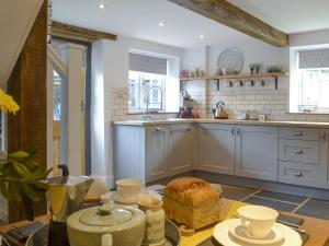 una cocina con una mesa con un pastel. en Grace Cottage, en Umberleigh Bridge