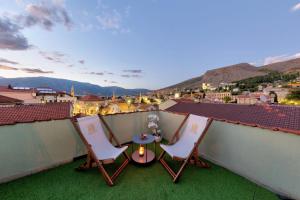 un patio con due sedie e un tavolo sul tetto di Hotel Sinan Han a Mostar