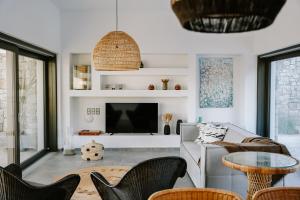 a living room with a couch and a tv at Hidden Hill Naxos Villas in Kastraki Naxou