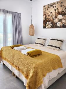 a bedroom with a bed with a yellow blanket on it at Hidden Hill Naxos Villas in Kastraki Naxou +81 photos