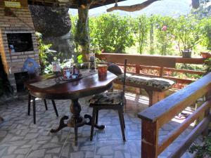 a wooden table and a bench on a patio at Fazenda Monte Verde a Morada do Muriqui in São Francisco Xavier