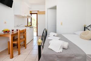 a kitchen and dining room with two beds and a table at Maridim studios in Ermoupoli