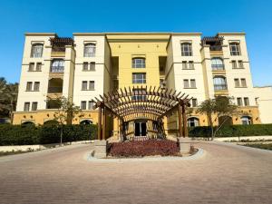 ein großes Gebäude mit einer Skulptur davor in der Unterkunft Sunny Cairo City Center l Serviced l Golf l Pool l Gym l 2 in Kairo