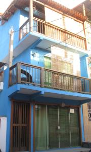 una casa azul con balcón en la parte superior en Linda Surf House Apartamentos, en Itacaré
