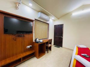 une chambre d'hôtel avec une télévision à écran plat et un bureau dans l'établissement S K Pushkar Resort, à Pushkar