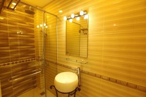 ein Bad mit einer Dusche, einem Waschbecken und einem Spiegel in der Unterkunft Nest Hotel in Ho-Chi-Minh-Stadt