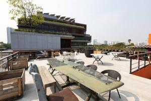 a patio with tables and chairs and a building at Orange Lodge in Bangkok
