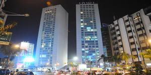 une ville de nuit avec de grands bâtiments et des voitures dans l'établissement marjana room, à Casablanca