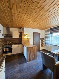 una cucina con soffitto in legno e tavolo di Ferienhaus Baumann mit Garten a Furth im Wald