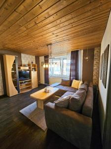 un soggiorno con un divano e un tavolo di Ferienhaus Baumann mit Garten a Furth im Wald