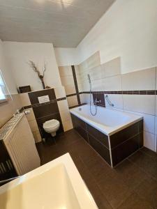 un bagno con una vasca bianca e un water di Ferienhaus Baumann mit Garten a Furth im Wald