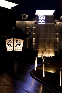 KoshidoHOTEL 翠 sui -TIMELESS GARDEN-的一座建筑,晚上有亚洲标志