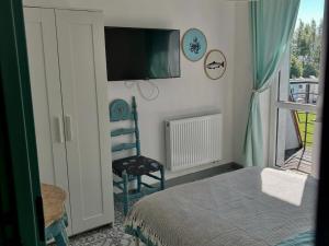 ミエルノにあるMessaのベッドとテレビと椅子のある寝室