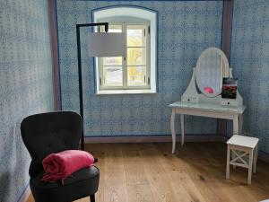 a room with a chair and a mirror and a table at DAS Donauhaus in Emmersdorf an der Donau
