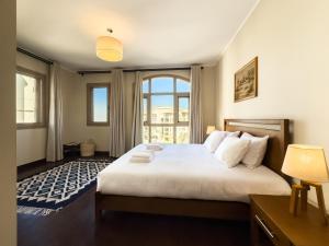 ein Schlafzimmer mit einem großen Bett mit einem großen Fenster in der Unterkunft Sunny Cairo City Center l Serviced l Golf l Pool l Gym l 2 in Kairo + 19 Fotos