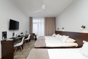 Una habitación de hotel con dos camas y un escritorio. en Hotel Biancas, en Kosakowo