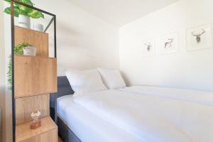 ein Schlafzimmer mit einem Bett und einem Bücherregal in der Unterkunft Zentrales Apartment mit Balkon direkt am Wanderweg - Alpenperle Tegernsee in Tegernsee